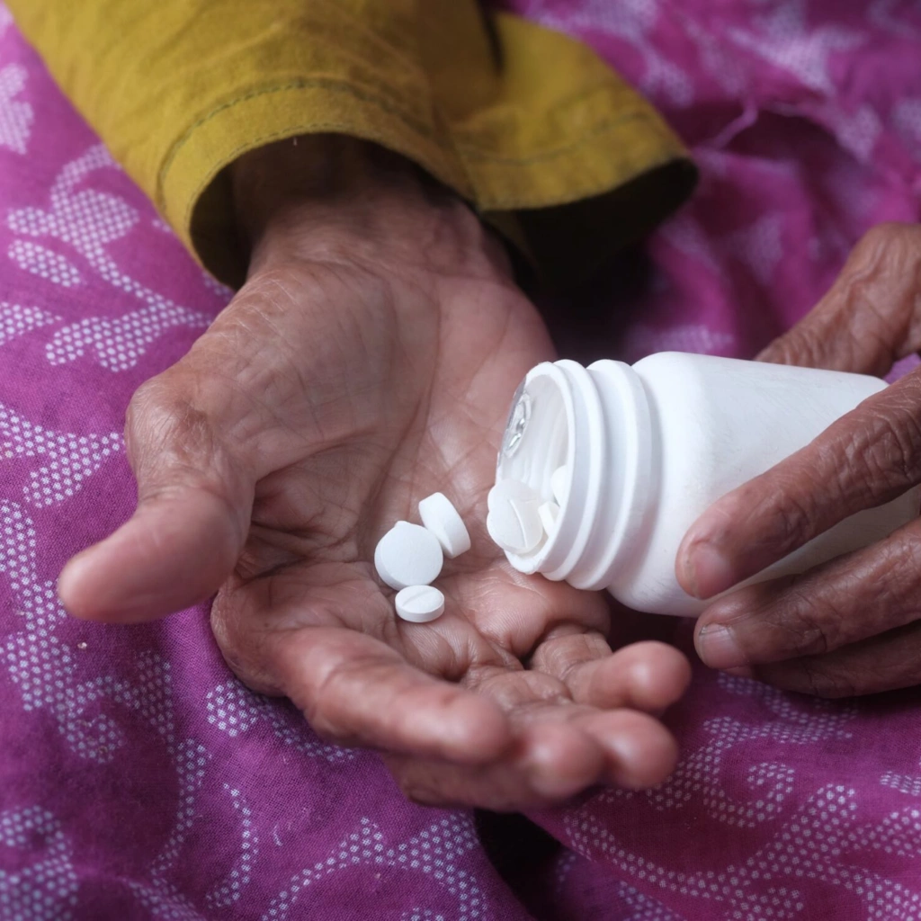pills in hands pink background